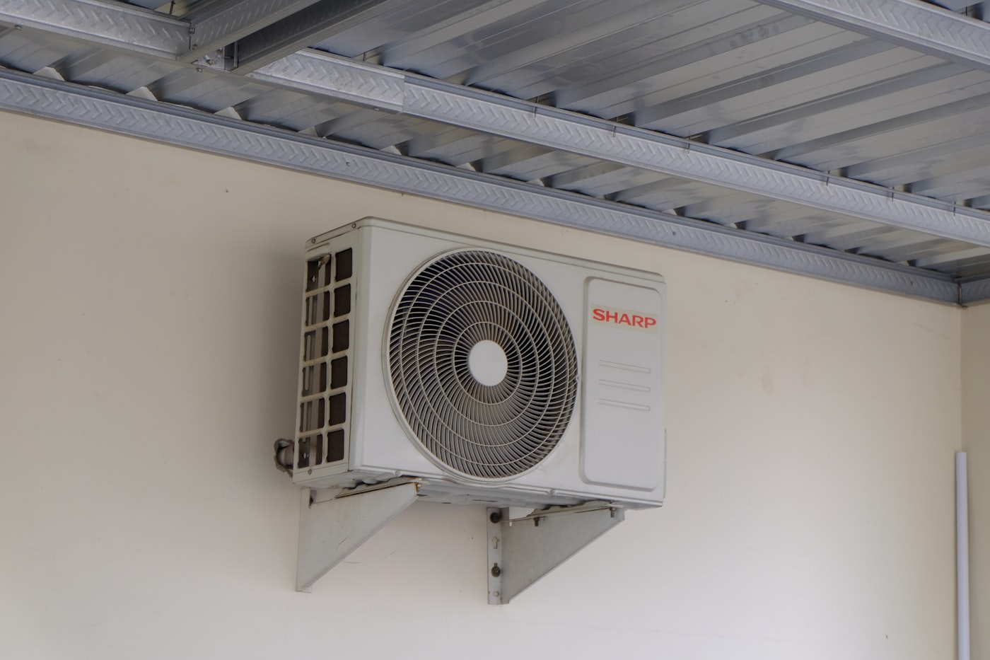 Unidad exterior de aire acondicionado instalada en la pared de un piso de Barcelona