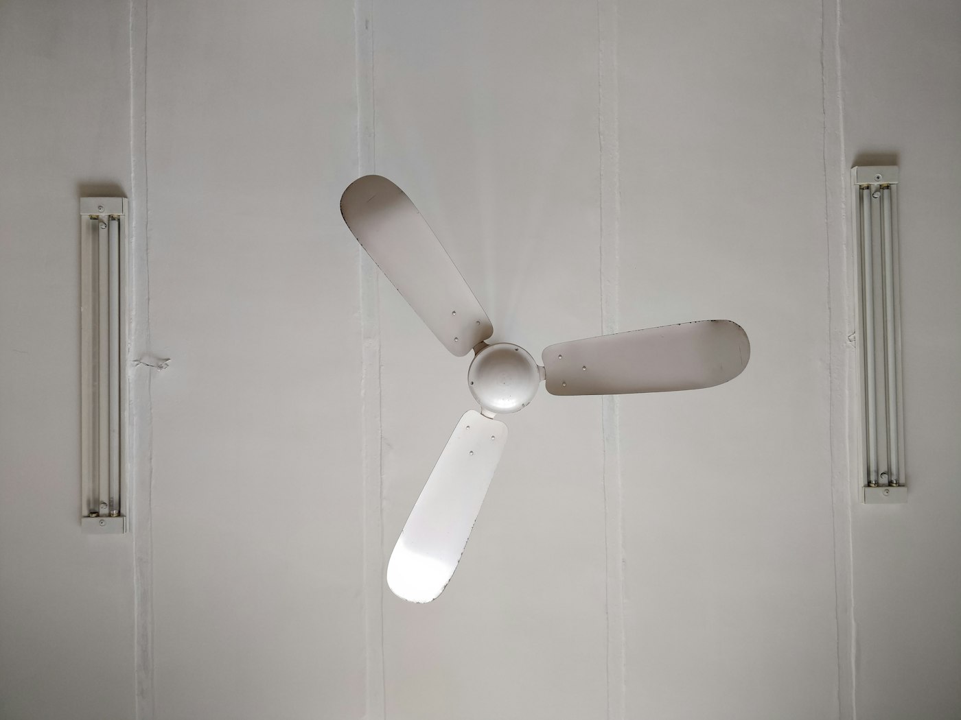 Ventilador de techo blanco de tres aspas ya instalado en el techo