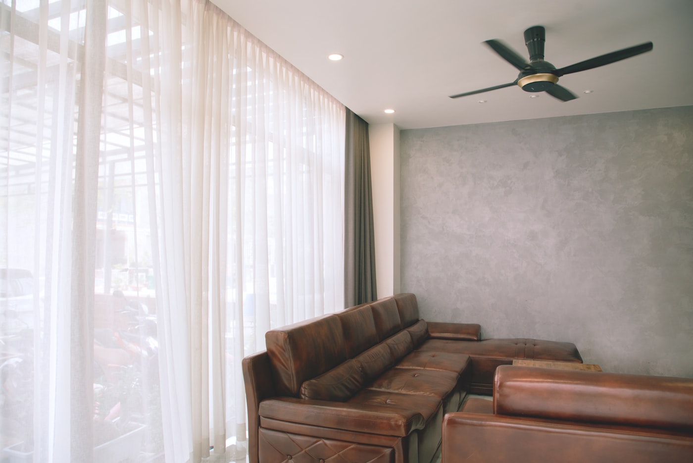 Salón con sofá y ventilador de techo negro instalado